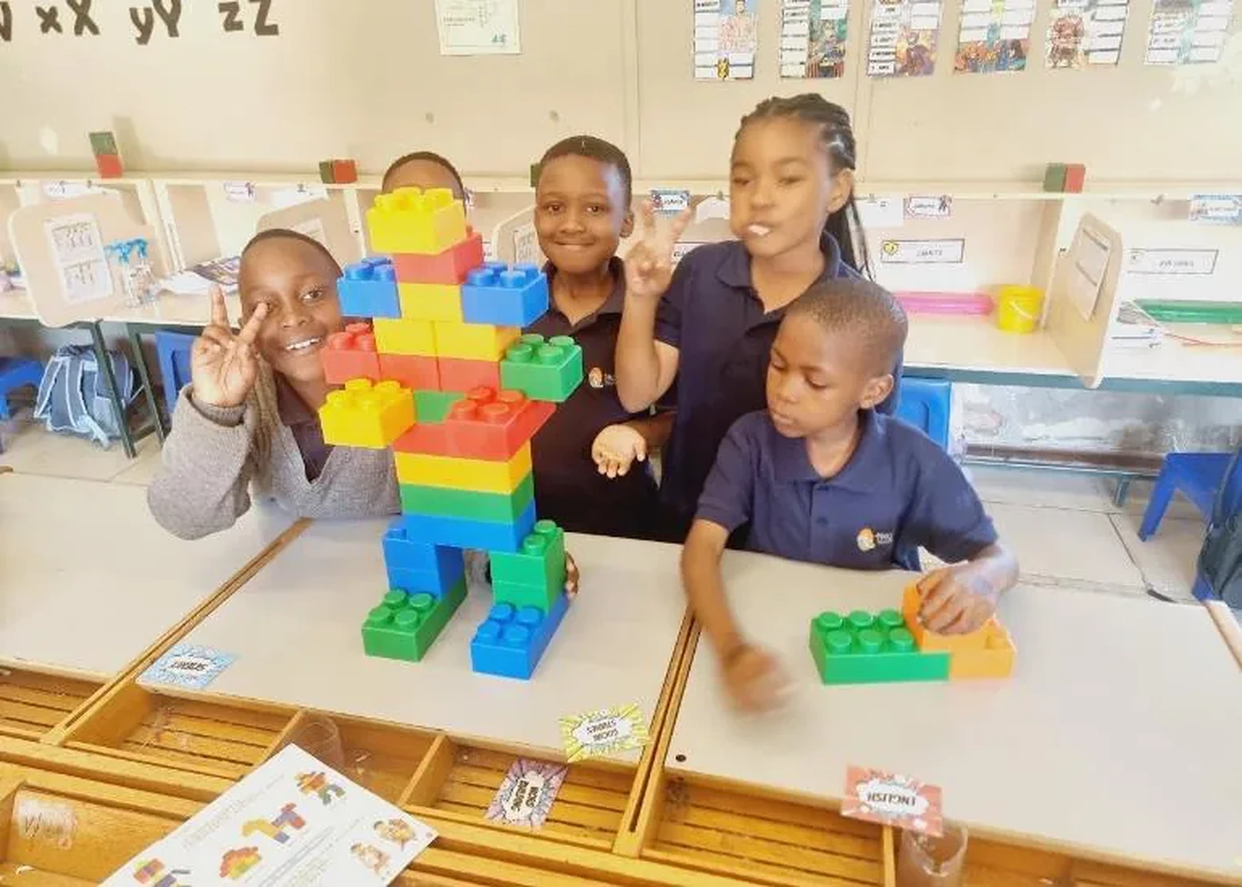 Foundation Phase learners proudly displaying a robot they built