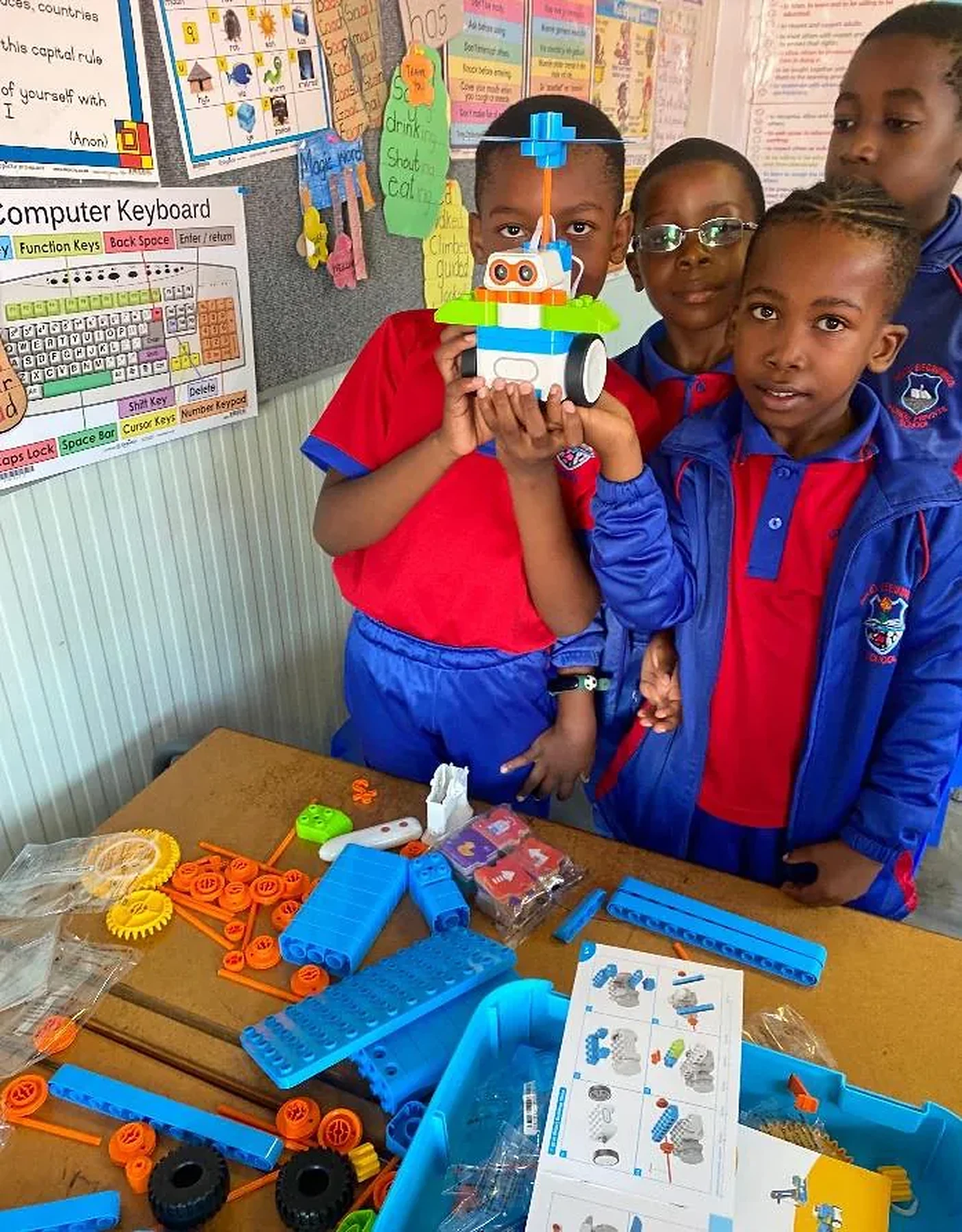 Young learners proudly displaying a robot